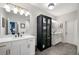 Bright bathroom featuring a large vanity, stylish lighting, and a glass-enclosed linen cabinet at 234 Retreat Ln, Canton, GA 30114