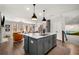 Open-concept kitchen showcases an island, stainless appliances, and seamlessly connects to the living area at 234 Retreat Ln, Canton, GA 30114