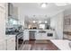 Updated kitchen with white cabinetry, stainless steel appliances, and a view into the living room at 241 Quail Run, Roswell, GA 30076