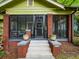 Close-up of inviting screened front porch with brick pillars and seating at 646 Catherine Sw St, Atlanta, GA 30310