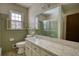 Bright bathroom featuring a window, toilet, and sink with white cabinetry and a large mirror at 1295 Maple St Se, Conyers, GA 30013