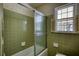 Bathroom view showcasing the shower-tub combo with glass doors and a window at 1295 Maple St Se, Conyers, GA 30013