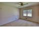 Vacant bedroom with carpeted floors, a ceiling fan, and a double window for natural light at 1295 Maple St Se, Conyers, GA 30013