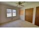 Bedroom with carpeted floors, a window, a ceiling fan, and a closet with wooden doors at 1295 Maple St Se, Conyers, GA 30013