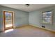 A bedroom with light blue walls, a doorway to a deck, and a window at 1295 Maple St Se, Conyers, GA 30013