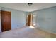 A bedroom featuring light blue walls, carpet, and a door leading to a bathroom at 1295 Maple St Se, Conyers, GA 30013