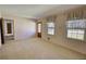 Carpeted living room featuring a decorative glass front door and multiple windows at 1295 Maple St Se, Conyers, GA 30013