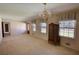 Large, carpeted living room with bright windows and a vintage chandelier at 1295 Maple St Se, Conyers, GA 30013