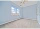 Bright, carpeted bedroom featuring a ceiling fan and a large window with city views at 140 Alden Nw Ave # 201, Atlanta, GA 30309