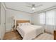 Bright bedroom features wood-look flooring, a ceiling fan, and a comfy bed with white linens at 178 Barone Nw Pl, Atlanta, GA 30327