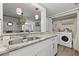 Bright laundry room adjacent to the kitchen with granite counters, hardwood floors, and front load washer and dryer at 178 Barone Nw Pl, Atlanta, GA 30327