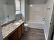 Bright bathroom featuring a granite countertop vanity, tub and shower, and wood-look flooring at 3518 Sable Glen, South Fulton, GA 30349