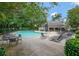 Community pool area with lounge chairs and tables, surrounded by mature trees and landscaping at 382 Leisure Sw Ct, Marietta, GA 30064