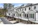 View of charming townhomes with white and grey exteriors, brick accents, and attached garages at 884 Mayfield Rd, Milton, GA 30009