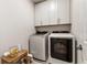 Well-organized laundry room with modern washer and dryer and stylish overhead cabinets at 884 Mayfield Rd, Milton, GA 30009