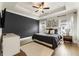 This main bedroom features a tray ceiling, a ceiling fan and an accent wall at 884 Mayfield Rd, Milton, GA 30009