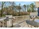 Exterior view of the wooden back deck with a grill, outdoor seating, and wooded backyard at 2468 Skyland Ne Dr # 32, Atlanta, GA 30319