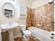 Bathroom with a pedestal sink, toilet, cabinet and tiled bathtub with shower at 2921 Royston Dr, Duluth, GA 30097