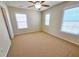 Cozy bedroom with neutral carpeting, a ceiling fan, and three windows for ample sunlight at 2921 Royston Dr, Duluth, GA 30097
