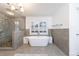 Elegant bathroom featuring a soaking tub, a modern chandelier, and a frameless shower at 3680 Sewell Mill Rd, Marietta, GA 30062