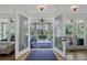 Elegant entrance featuring double glass doors leading to a covered porch with outdoor seating and ceiling fans at 3680 Sewell Mill Rd, Marietta, GA 30062