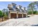 Three car garage with carriage doors and concrete driveway provides ample parking at 3680 Sewell Mill Rd, Marietta, GA 30062
