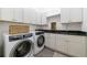 Bright laundry room featuring modern washer and dryer, granite countertops, and ample cabinet space at 3680 Sewell Mill Rd, Marietta, GA 30062