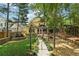 Backyard with a fountain, a stone fire pit area, and landscaping leading to a charming yellow home at 518 Hill St Se, Atlanta, GA 30312