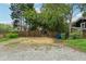 Large backyard with gravel area, partial fencing, and mature trees offering privacy and space at 518 Hill St Se, Atlanta, GA 30312