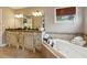 Bathroom features a soaking tub, double sink vanity with marble countertops, and neutral tile flooring at 518 Hill St Se, Atlanta, GA 30312