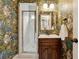 This bathroom showcases unique monkey wallpaper, a glass-enclosed shower, vanity with mirror, and stylish fixtures at 518 Hill St Se, Atlanta, GA 30312