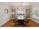 This dining room features a round table, hardwood floors, stylish chandelier, and decorative shelving flanking the window at 518 Hill St Se, Atlanta, GA 30312