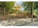 Beautiful two-story yellow home, featuring a stone wall with a landscaped and tiered yard at 518 Hill St Se, Atlanta, GA 30312