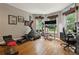 A well-lit home gym with hardwood floors and a variety of exercise equipment by the windows at 518 Hill St Se, Atlanta, GA 30312