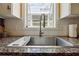 Stainless steel kitchen sink with granite countertops and white tile backsplash at 518 Hill St Se, Atlanta, GA 30312