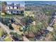 Areal view of a beautiful home surrounded by lush trees and a scenic pond in the distance at 1768 Hood Rd, Dacula, GA 30019