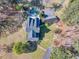 An aerial view shows a property with a pool, a residence, outbuildings, and mature landscaping at 1768 Hood Rd, Dacula, GA 30019