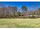 Large backyard with a serene pond surrounded by mature trees, perfect for outdoor relaxation at 1768 Hood Rd, Dacula, GA 30019