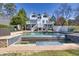 Stunning backyard with a large swimming pool, waterfall feature, and beautiful white home exterior at 1768 Hood Rd, Dacula, GA 30019