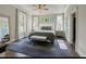 Bright bedroom featuring light gray walls, large windows and stylish blue rug with a bench at the foot of the bed at 1768 Hood Rd, Dacula, GA 30019