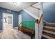 Inviting foyer with staircase, stained wood flooring, painted accent wall, and a unique repurposed bench at 1768 Hood Rd, Dacula, GA 30019