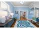 Elegant foyer with staircase, hardwood floors, stylish rug, and bright blue walls at 1768 Hood Rd, Dacula, GA 30019