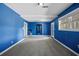 Bright game room featuring blue walls, gray carpet, and natural light from windows and a door at 1768 Hood Rd, Dacula, GA 30019