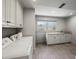 Bright laundry room with white cabinetry, granite countertops, and modern appliances at 1768 Hood Rd, Dacula, GA 30019