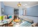 Light blue living room with a vibrant, patterned rug and a cream-colored sofa, filled with natural light at 1768 Hood Rd, Dacula, GA 30019