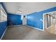 Spacious living room featuring bright blue walls, neutral carpet, and natural light from large windows at 1768 Hood Rd, Dacula, GA 30019