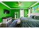 A green bedroom featuring a ceiling fan, large window, and dark wood floors create a relaxing retreat at 1768 Hood Rd, Dacula, GA 30019