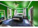 Stylish bedroom with vibrant green walls, modern decor, and plenty of natural light streaming through the windows at 1768 Hood Rd, Dacula, GA 30019