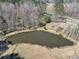 Aerial view of pond surrounded by lush greenery and trees, creating a tranquil retreat at 1768 Hood Rd, Dacula, GA 30019