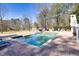 Inviting swimming pool surrounded by brick patio, lounge chairs, and lush landscaping at 1768 Hood Rd, Dacula, GA 30019